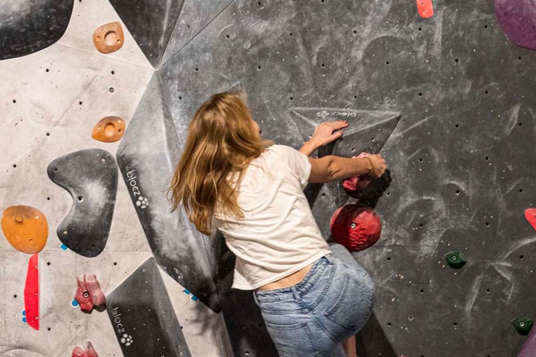 Een student klimt op een boulderwand