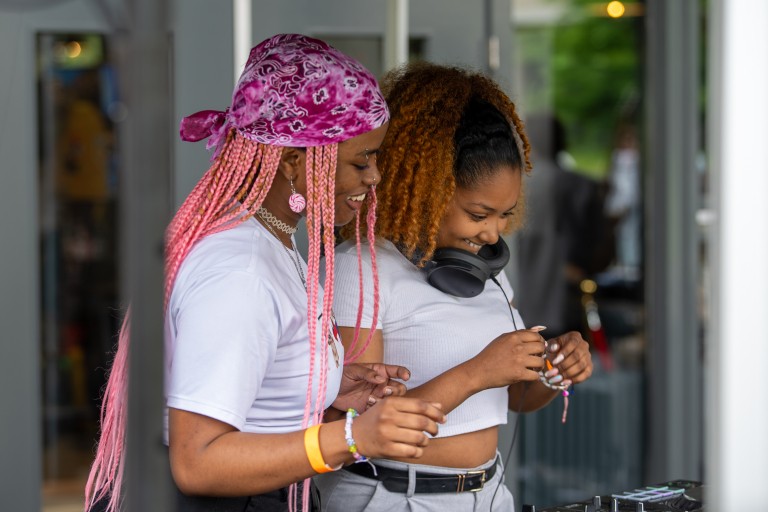 Twee meisjes staan achter een dj-set