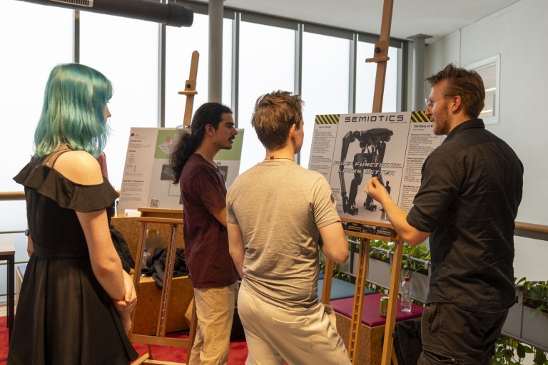 Een docent bekijkt studentenwerk op Industry Day 