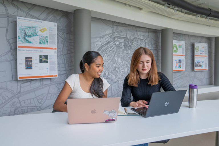 Twee studenten werken samen aan een tafel 