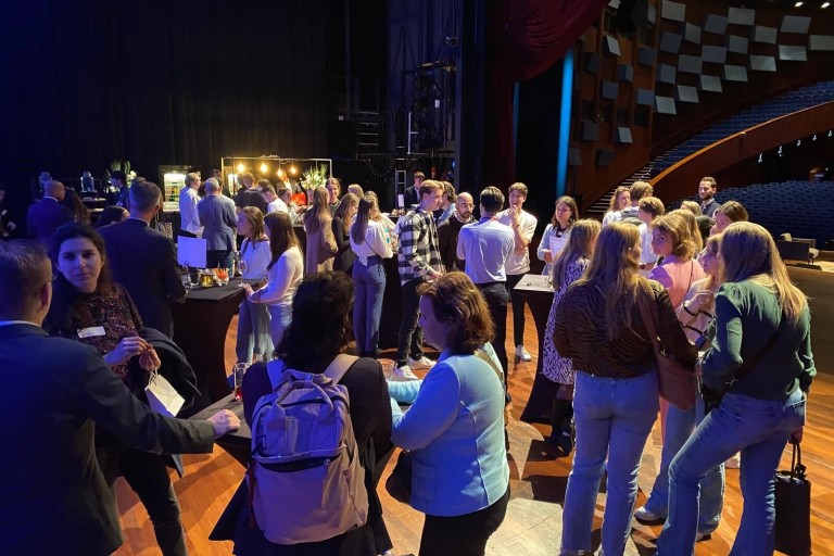 Een groep mensen praat op het podium van een concertzaal