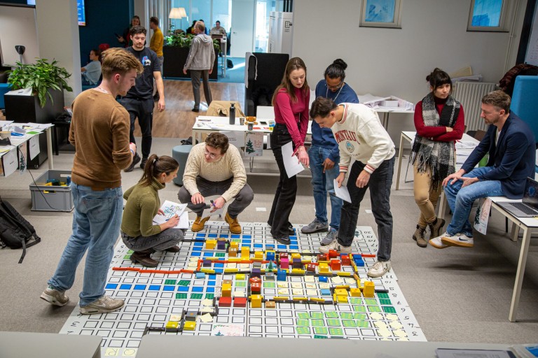Studenten werken samen aan een groot model van een stad 