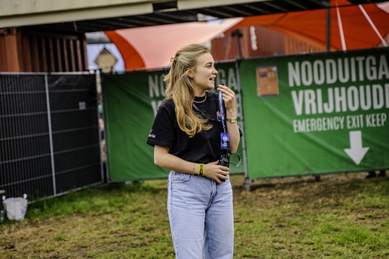Een vrouw op een festival zegt iets door een portofoon 