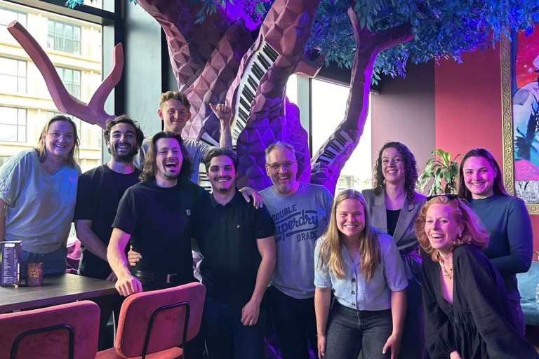 Groepsfoto van studenten en docenten in een restaurant