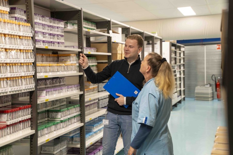 Twee mensen staan in een medische voorraadkast