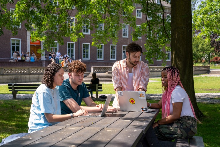 Vier studenten zitten aan een tafel op de BUas campus