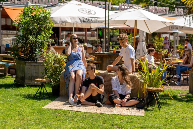 Studenten zitten bij een terras in een park