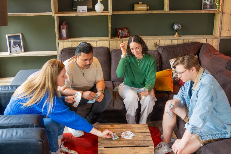 Vier studenten spelen samen een kaartspel