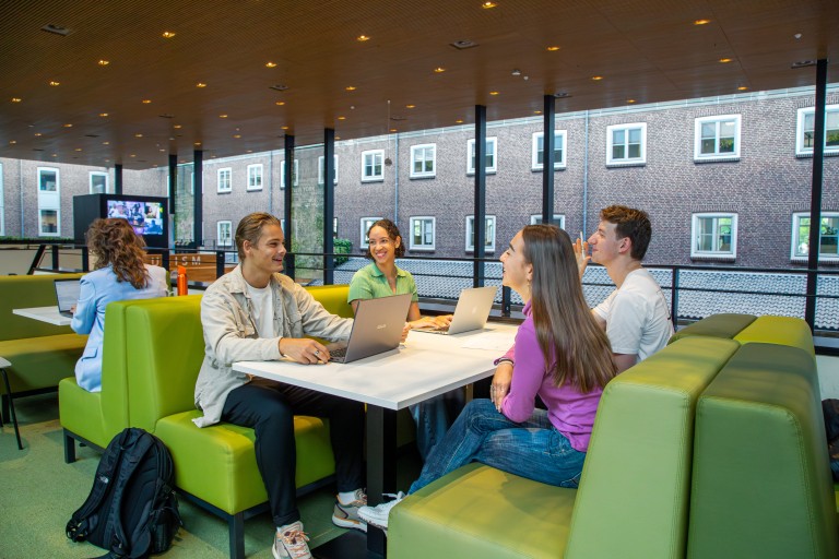 Vier studenten zitten samen aan een tafel