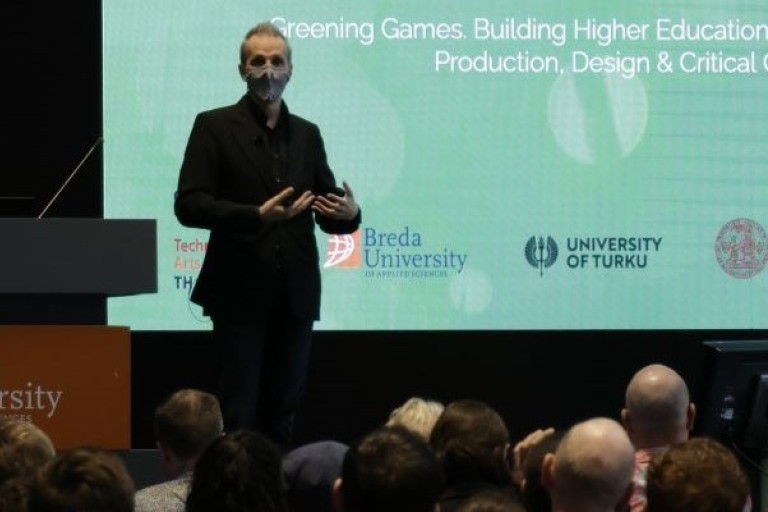 Een man geeft een presentatie over het vergroenen van games