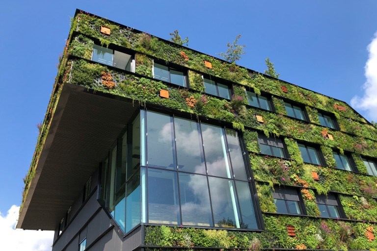 Een gebouw met planten op de buitenmuren