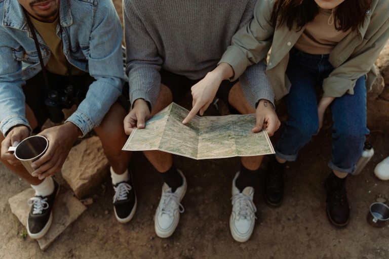 Drie zittende vrouwen kijken samen op een landskaart