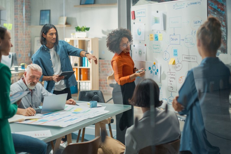 Een groep mensen werkt in een glazen ruimte aan een project