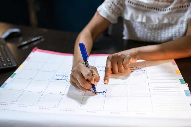 Een vrouw schrijft iets op een kalender