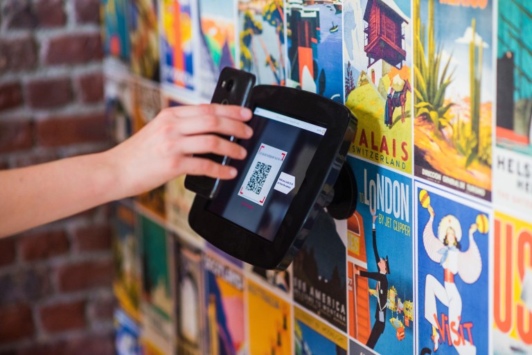 Een telefoon scant een QR-code op een beeldscherm