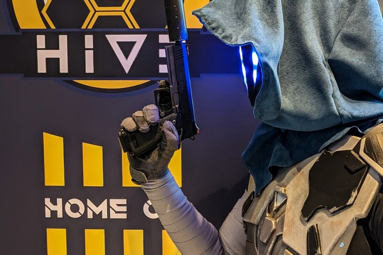 Een persoon met een capuchon houdt een wapen vast