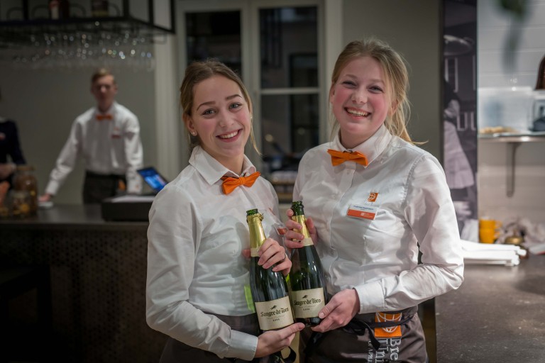 Twee studenten houden een fles cava vast