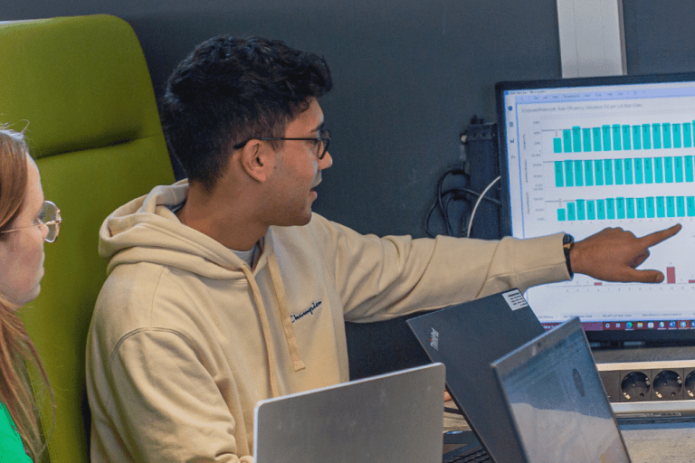 Een student toont medestudenten iets op een beeldscherm