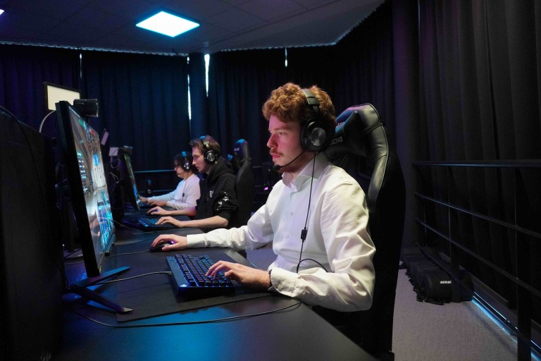 Een student werkt op een desktopcomputer