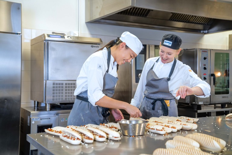 Twee studenten maken broodjes in een keuken