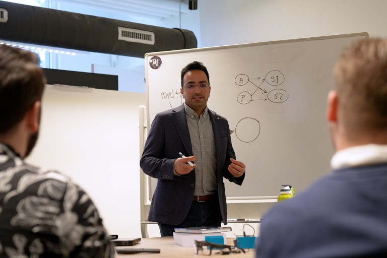 Een docent geeft uitleg voor een whitebord