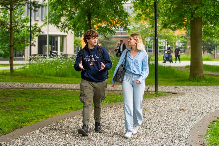 Een student en studiekiezer lopen over de BUas campus