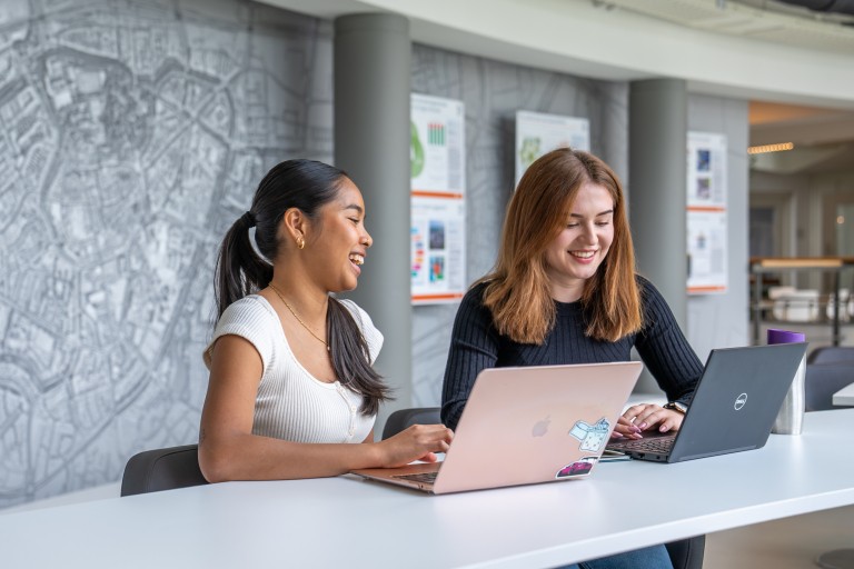 Twee studenten werken op een laptop