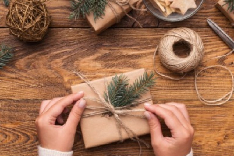 Een vrouw doet een strik om een cadeau