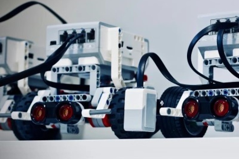 Drie robotwagens staan op een plank