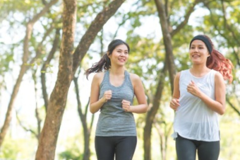 Twee vrouwen rennen in een park