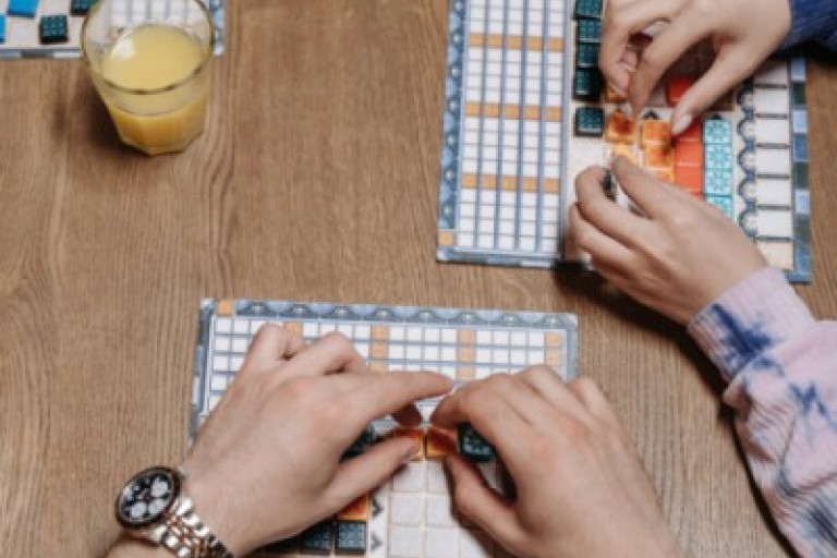 Drie mensen spelen een spel aan een tafel