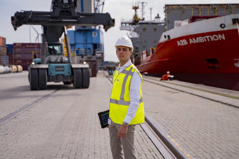 Man voor een containerschip in een haven