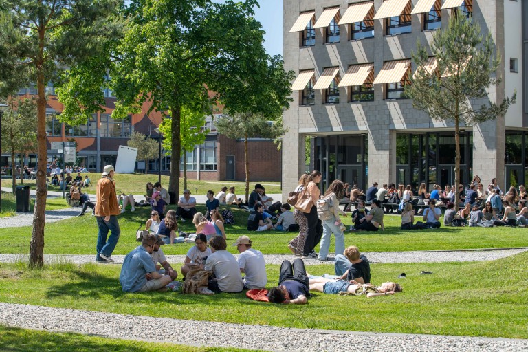 Studenten in het gras buiten op de BUas campus