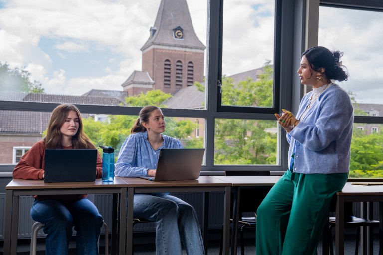Twee studenten en een docent aan het werk