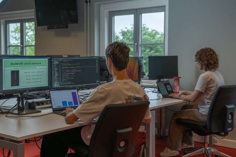 Twee studenten aan het werk achter een pc