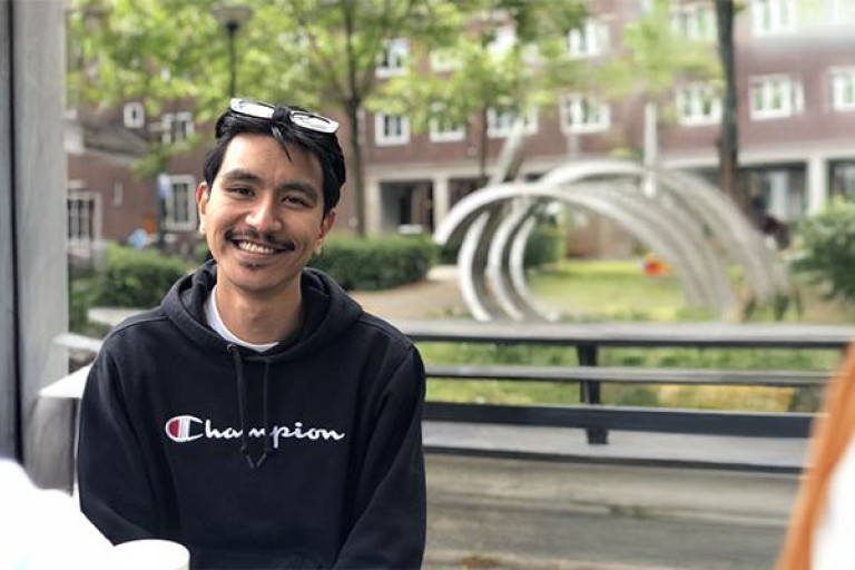 Kevin zit buiten bij de campus