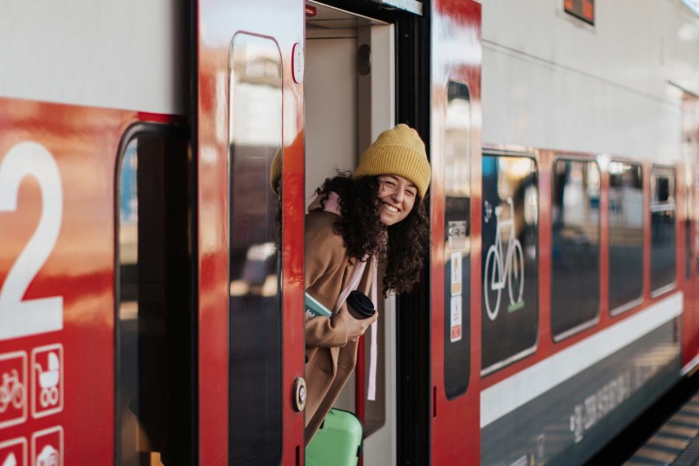 Persoon staat in de deuropening van een trein