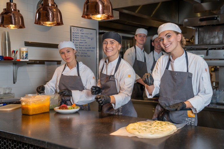 Studenten aan het werk in de keuken van restaurant Sibelicious