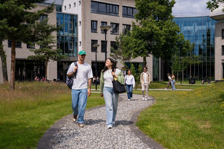 Twee studenten lopen over het campus terrein