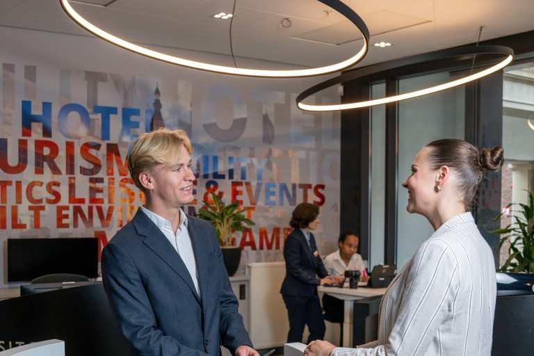 Receptionist in gesprek met bezoeker