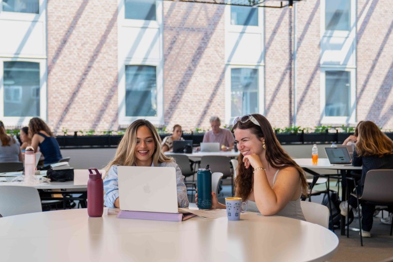 two students with a laptop
