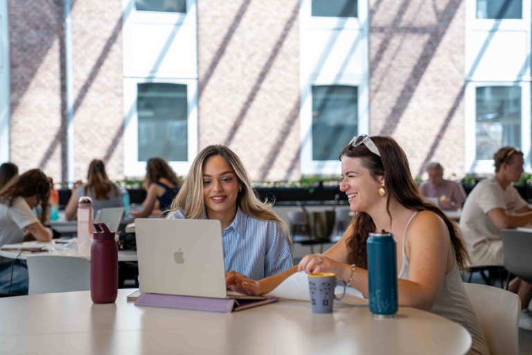 two students with a laptop