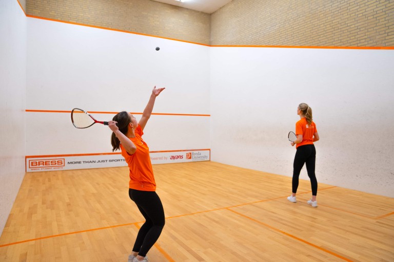 Two students playing squash