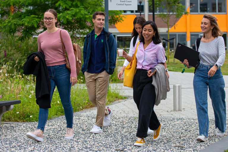 Vijf studenten lopen over de BUas campus
