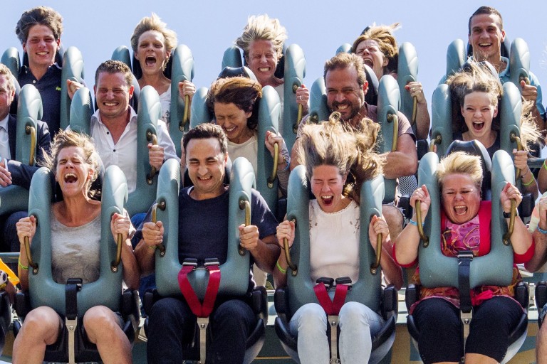 Gillende mensen in een achtbaan
