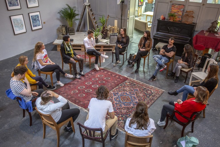 Studenten zitten op stoelen in een kring