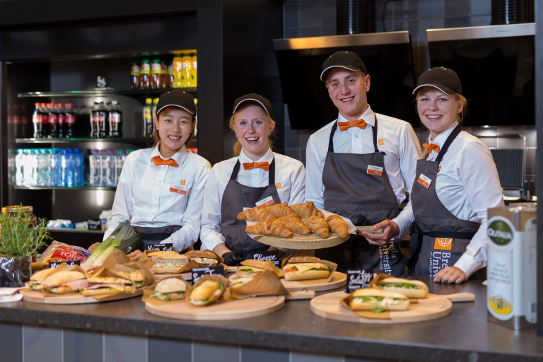 Vier studenten staan achter de balie van een BUas food court
