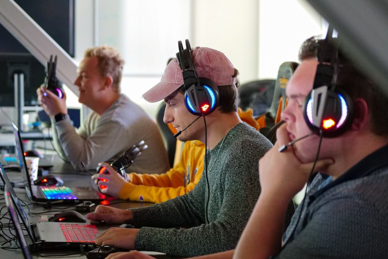 Drie studenten spelen een videogame