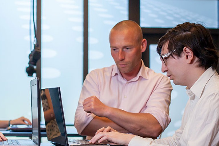 Twee mensen bekijken iets op een computer