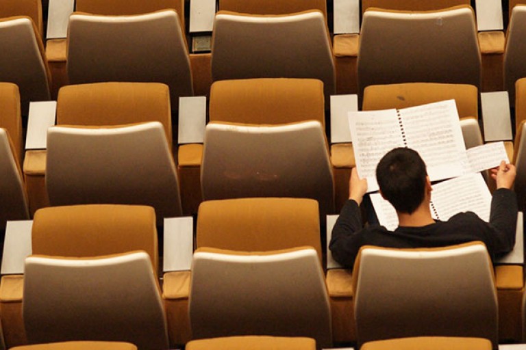 Een verlaten collegezaal waar nog 1 student is